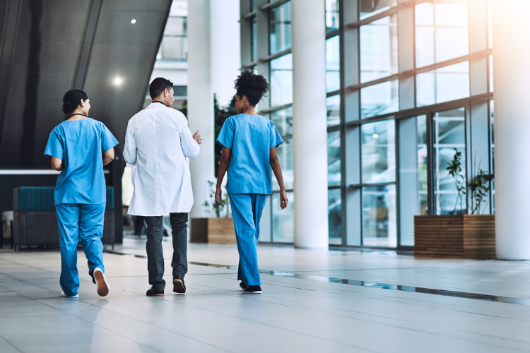 three healthcare workers walking away from the camera