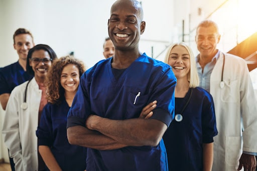 A group of healthcare professionals poses for the camera. They are diverse and represent today's modern medical facility.