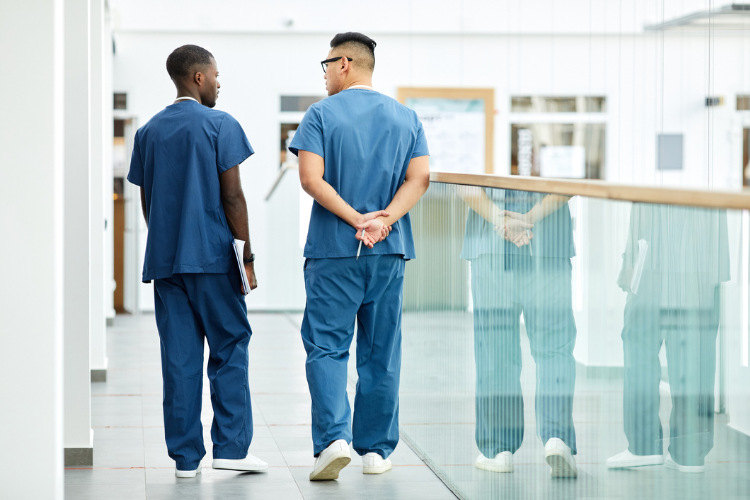two healthcare professionals walking in a hallway