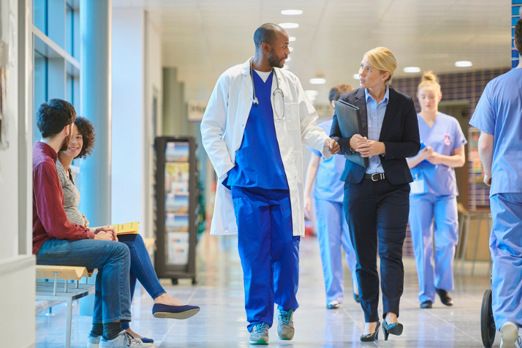 healthcare professional and administrator walking in crowded hospital