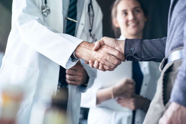 Physician and another man shaking hands