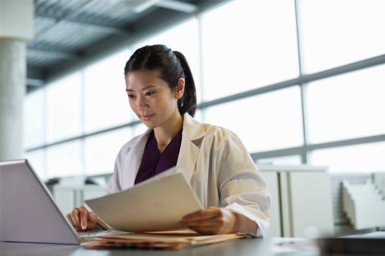 Female doctor entering a report into a computer for healthcare risk management