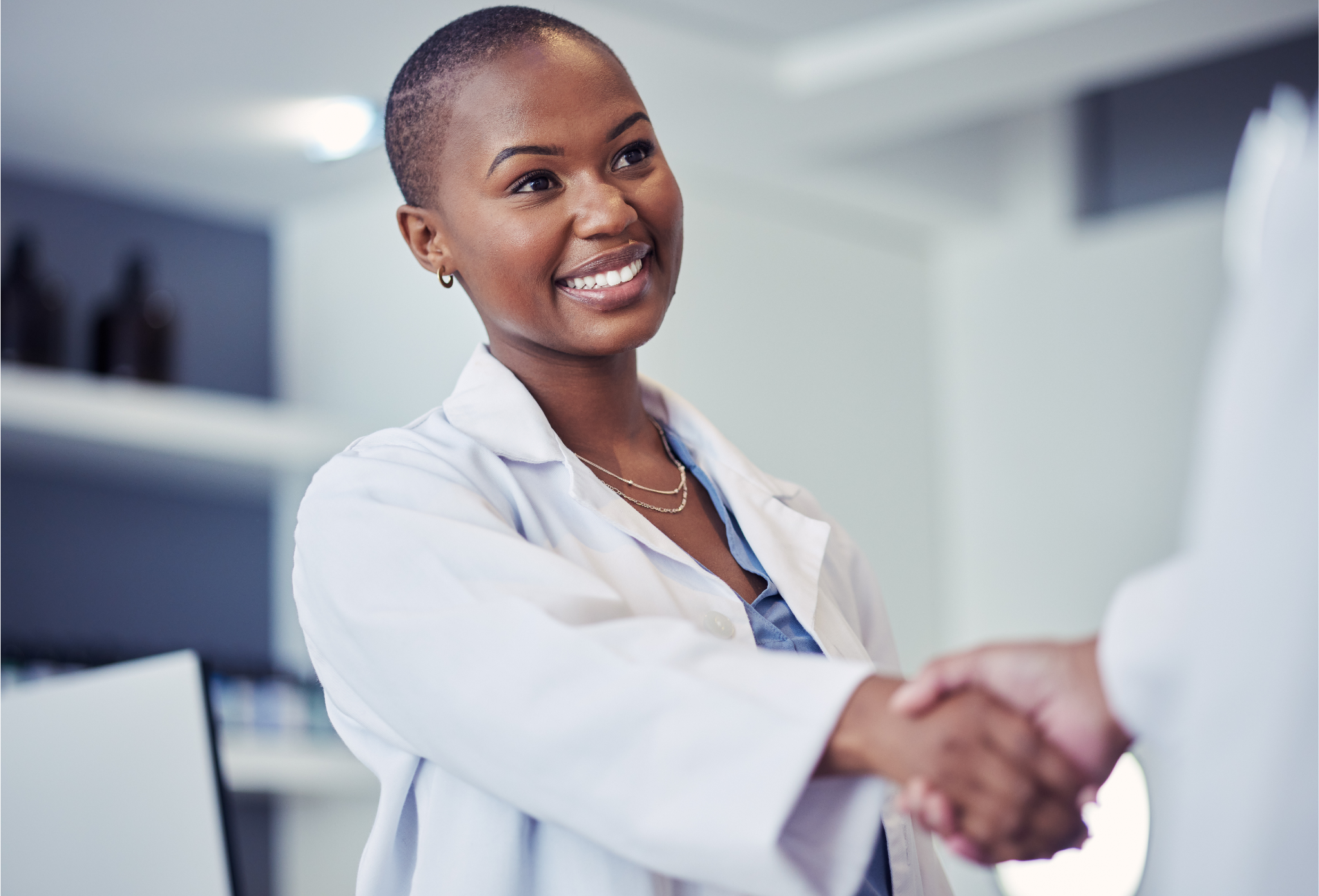 Female doctor smiling and sharing hands with an administrator