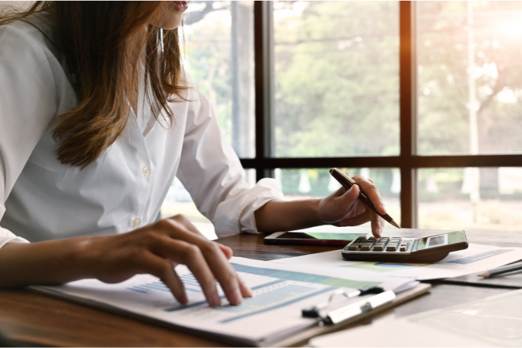 Woman at desk with calculator and clipboard