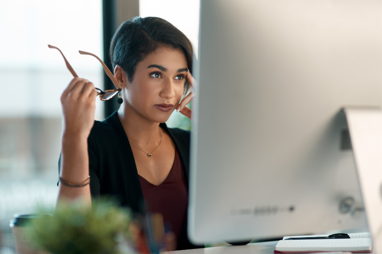 Woman looking thoughtfully at computer