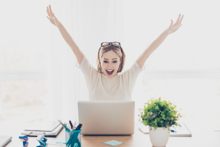 Woman behind a computer happy and cheering