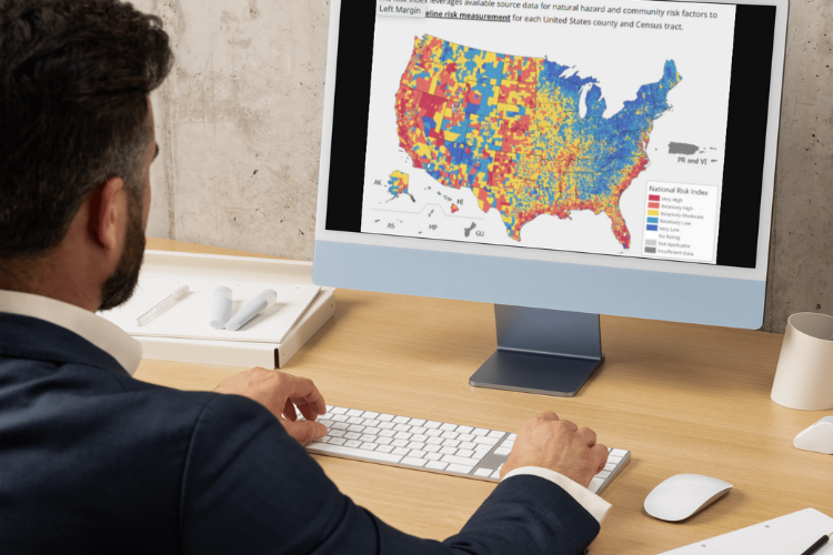 Man sitting at a computer with FEMA National Risk Index on computer screen