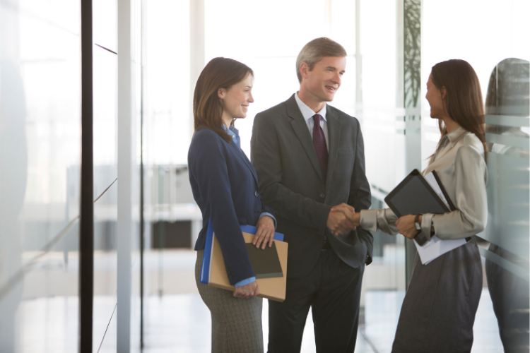 Three business people standing in hallway talking