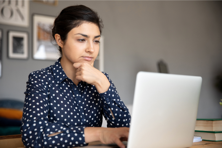 Woman sitting and starting at laptop